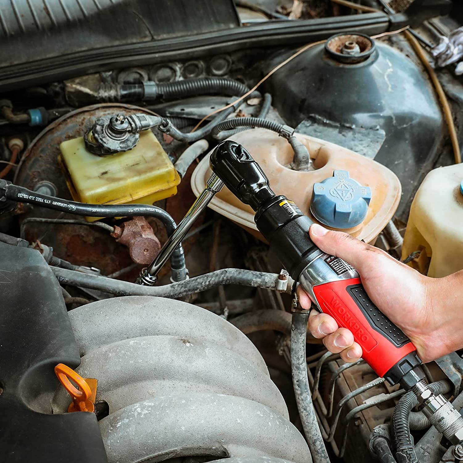 WORKPRO pneumatic ratchet wrench with red handle held near engine components