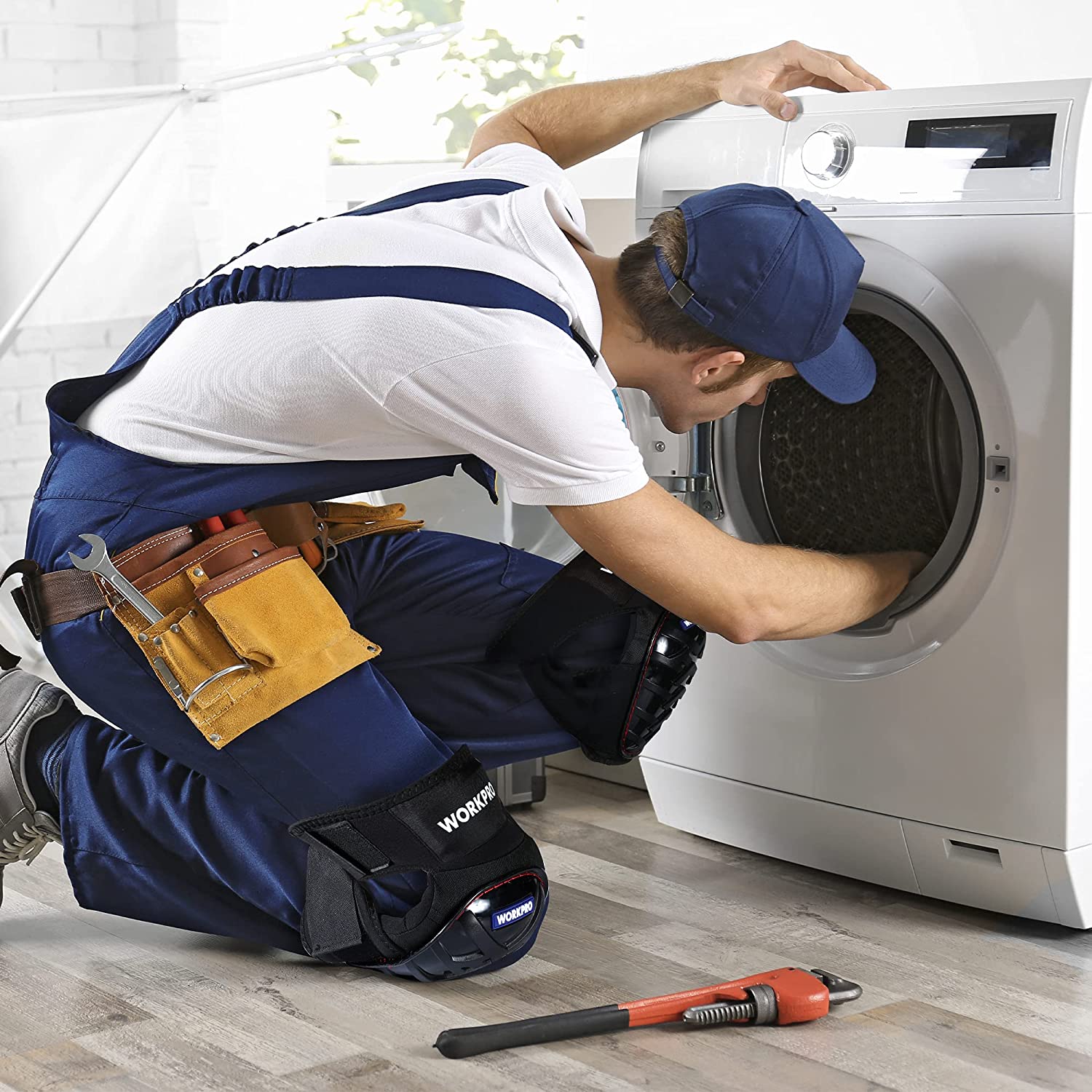 Black gel knee pads on a worker kneeling during appliance work