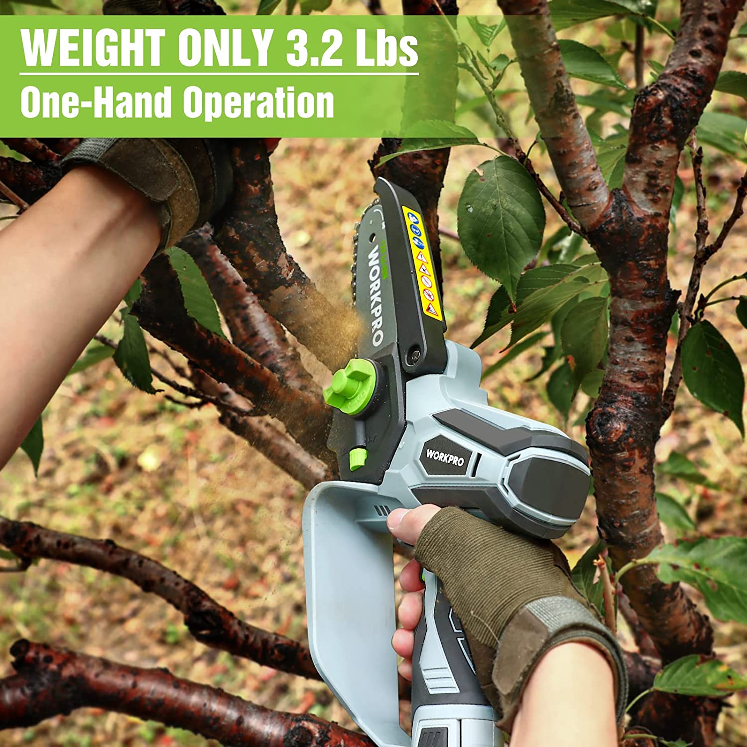 Cordless mini chainsaw in hand with light gray body and green thumb control