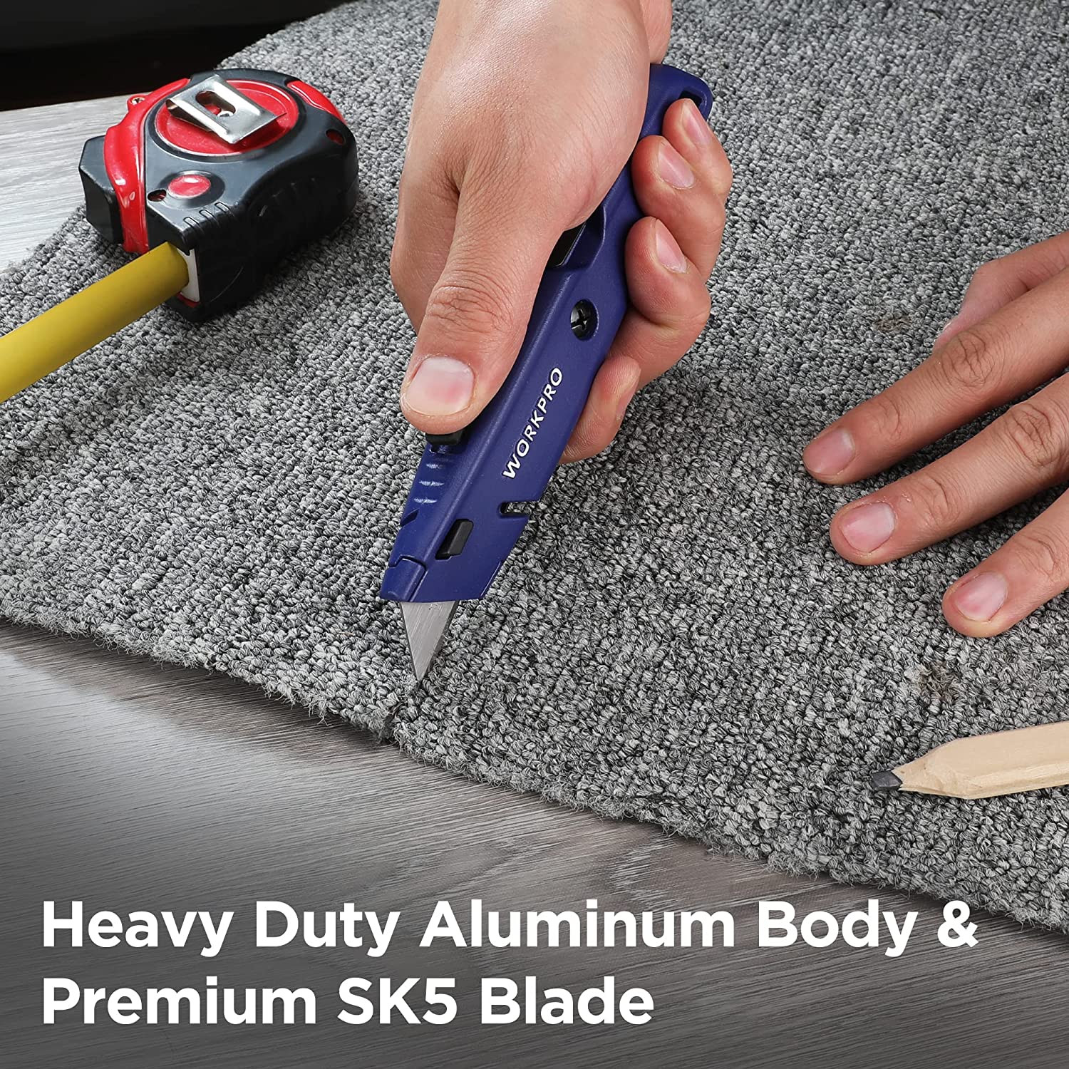 Retractable utility knife with blue handle held to cut carpet edge