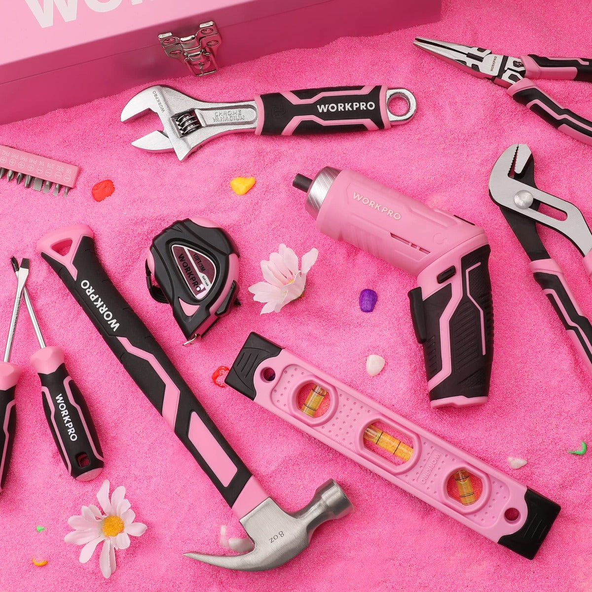 Pink tool set accessories laid out: screwdriver, wrench, measuring tool, and case