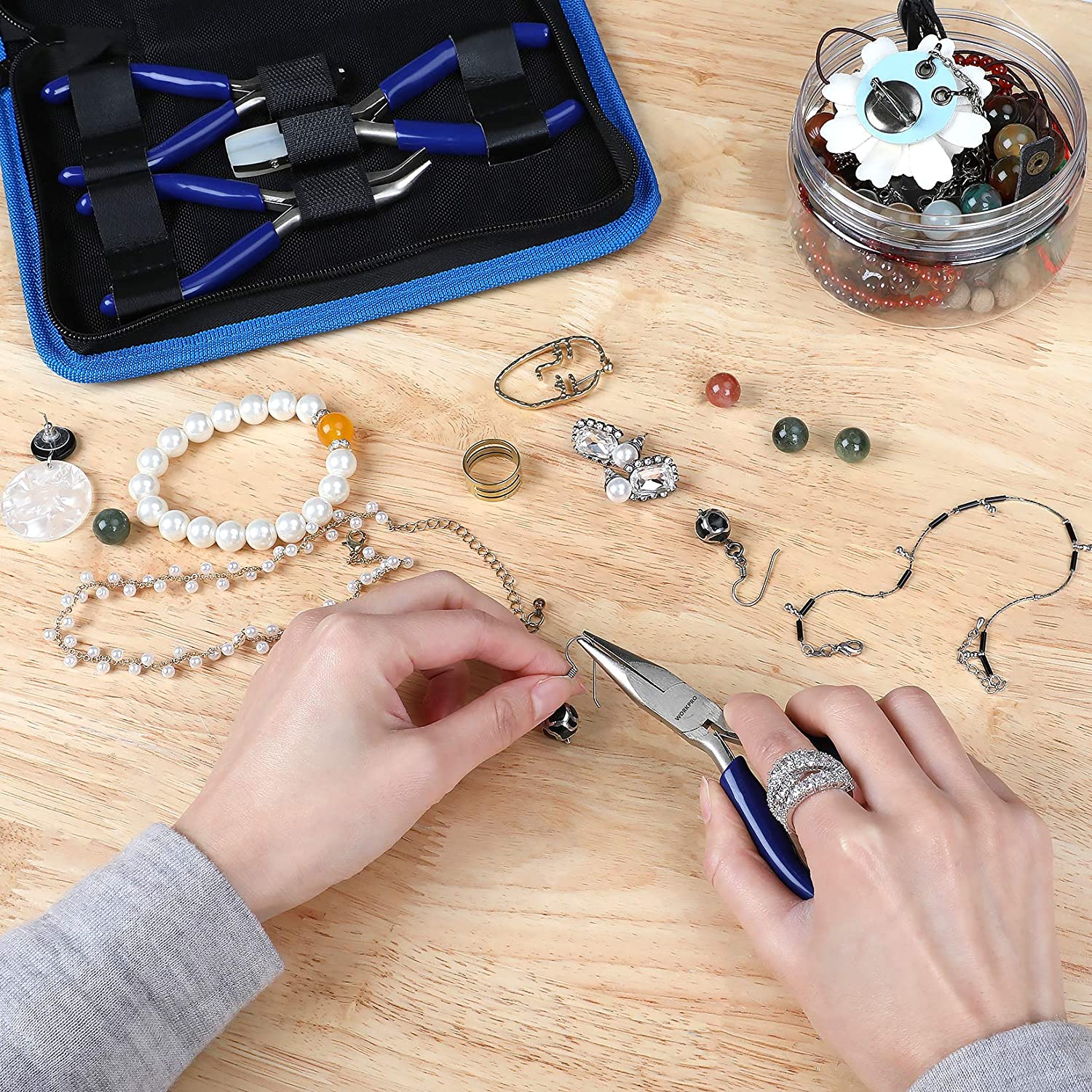 Jewelry pliers with blue handles used to assemble beads and wire on a wooden table
