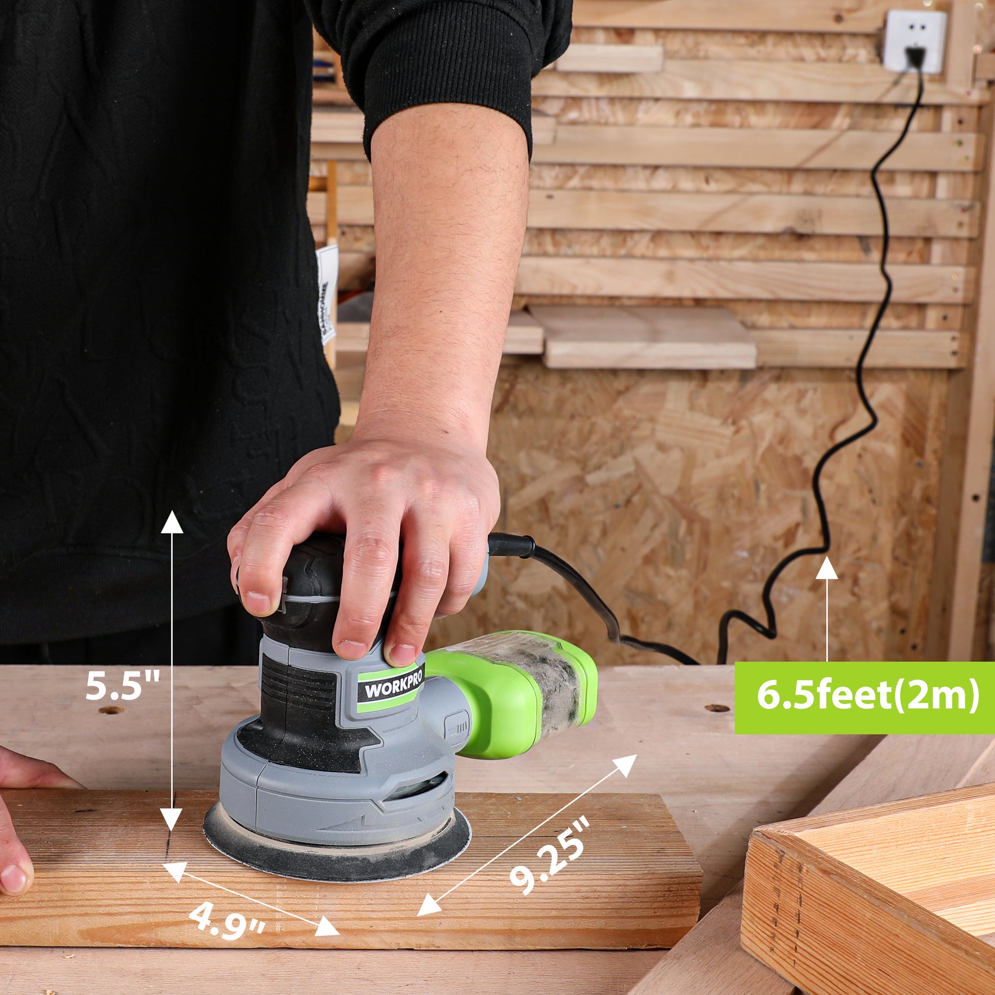 Handheld random orbit sander sanding a wooden board on a workbench