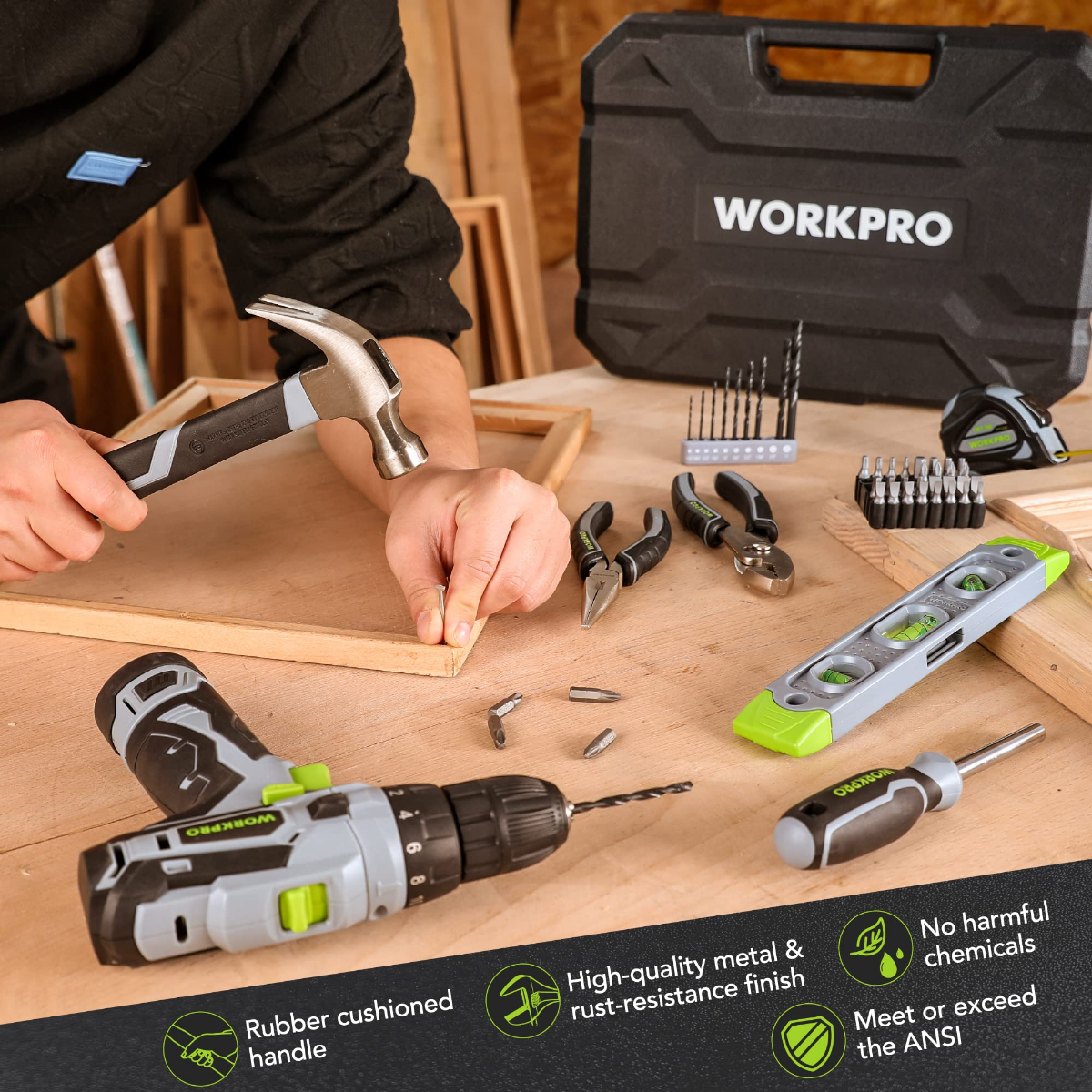 Cordless drill driver with hand tools, hammer, and bits arranged on wooden board